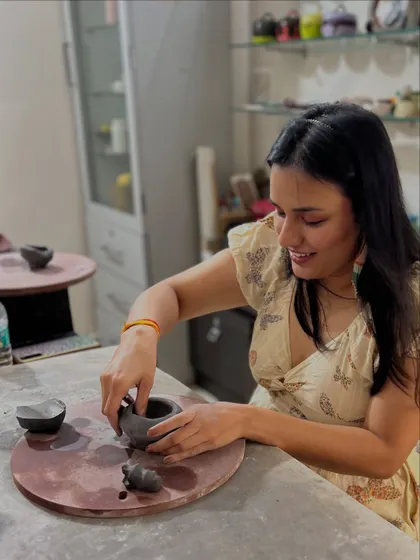 A smile of satisfaction during an anniversary pottery session. There's nothing like the feeling of bringing your own idea to life in clay.