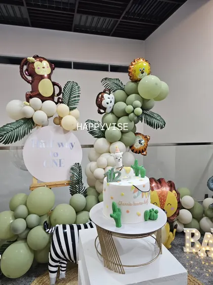 A modern and minimalist take on a safari theme. This setup uses a soft green and white color palette, with animal-print foil balloons and a simple backdrop for a clean, contemporary look.