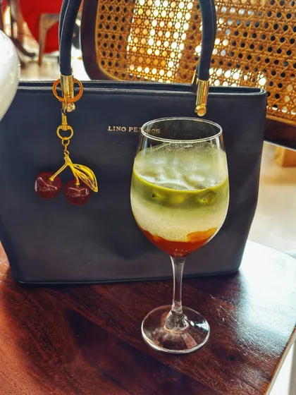 An aesthetic shot of a layered matcha latte next to a stylish handbag. This type of content captures a mood and is perfect for brands that align with a chic, modern, and calm lifestyle.