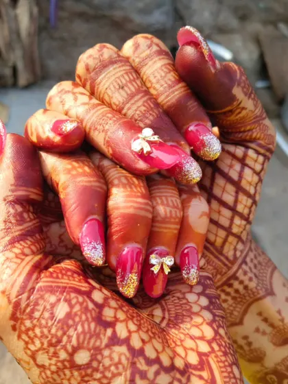 For the bride who loves a bold look. This set features a vibrant magenta base, sparkling gold glitter tips, and an adorable 3D bow accent nail for a fun and festive touch.