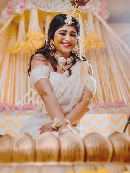 Capturing the pure joy of the Haldi ceremony. The bride is showered with flowers and turmeric, and my decor with its bright yellow drapes and floral accents creates a perfectly festive atmosphere.