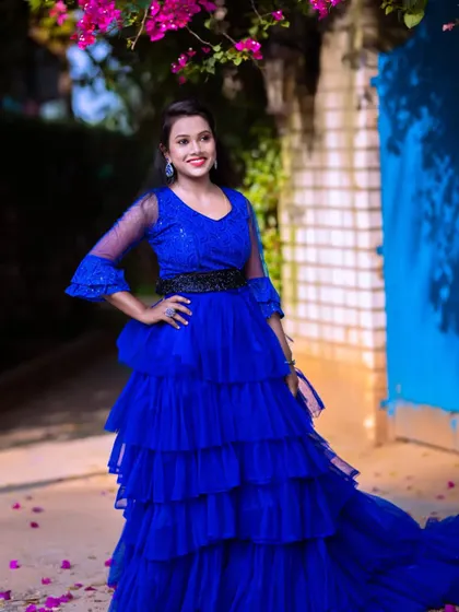Our client is all smiles in this royal blue tiered ruffle gown. It's a fun, vibrant, and stylish choice for any party or event.