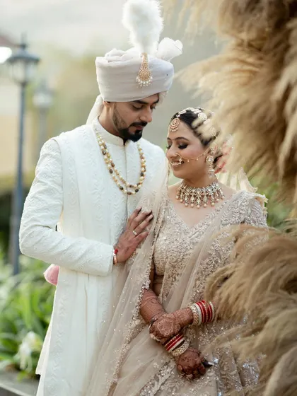 A classic wedding portrait of Nidhi and Ruchit. They look absolutely regal in their coordinated white outfits, a timeless image from their special day.