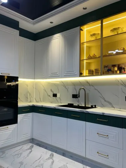 This shot captures the beautiful interplay of light in the classic kitchen, with under-cabinet LEDs and internal lighting in the glass unit creating a warm and inviting atmosphere.