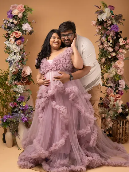 A warm hug from behind, celebrating the double blessing on the way. This couple's love and strength shine through.