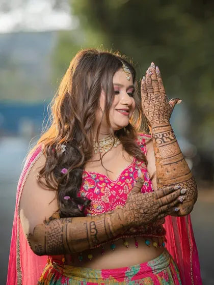 Showcasing her beautiful henna design. The bride's makeup is kept fresh and radiant, ensuring her natural glow is the highlight of her Mehendi look.