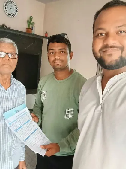 Our team member with a customer holding his new solar agreement.