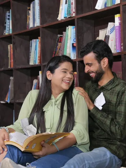Another shot from the library-themed pre-wedding setup. The natural makeup ensures the focus is on the couple's happy expressions.