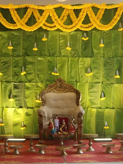For a classic South Indian feel, we designed this backdrop using fresh banana leaves. The setup is complemented by marigold garlands and an ornate chair for the mother-to-be.