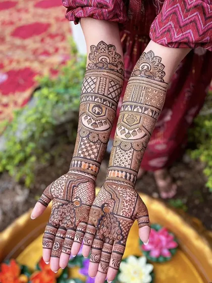 This full-arm bridal design combines geometric patterns with traditional motifs. The structured bands on the forearm create a beautiful contrast with the more flowing, organic patterns on the palm and fingers.