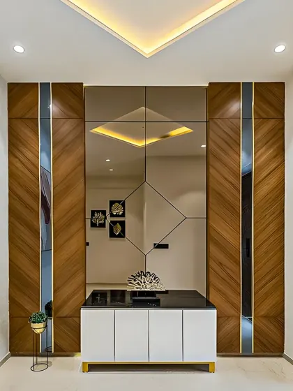An elegant foyer unit with a large central mirror to create a sense of space. The unit is flanked by tall cabinets with a beautiful diagonal wood grain pattern and metallic accents.