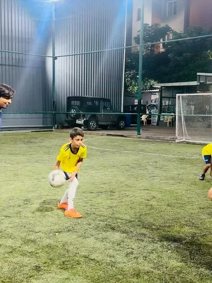 A coach observes as a young player practices his ball-throwing technique. Every detail is important in a player's development.
