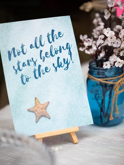 Inspiring little messages are a sweet addition to the decor. This sign, reading "Not all the stars belong to the sky," adds a touch of magic to the starfish-themed setup.