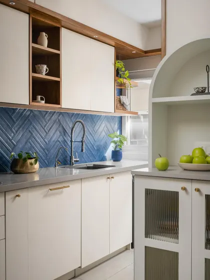 Another angle of the 'Palaash' kitchen, showing the fluted glass cabinetry and arched niche that add a touch of softness and character.