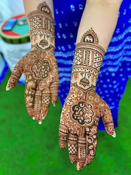 A beautiful wedding mehendi with clover-like floral motifs on the palm and elephant toppers on the wrist.