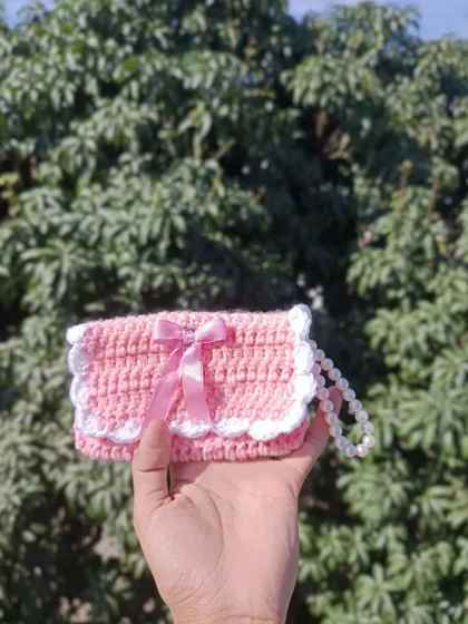 A sweet pink pocket purse with a white scalloped edge and a satin bow. This design is very popular for event giveaways and college fests.