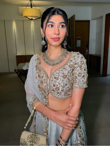 A classic soft glam look with a glossy lip. The pearls in her hair add a touch of timeless elegance to this modern outfit.