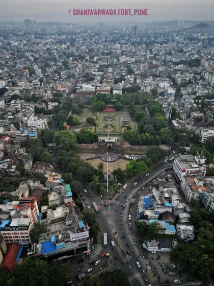 A top-down aerial view of Shaniwar Wada in Pune, showing the historic Maratha fort's foundations and gardens surrounded by the modern city.