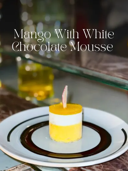 My Mango with White Chocolate Mousse is a three-layered tropical treat. It features a soft sponge, a creamy mango mousse, and a velvety white chocolate mousse, all topped with a shiny mango glaze.