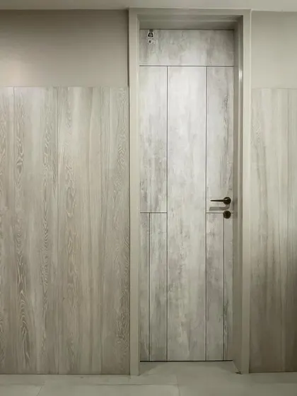 The restroom doors in the VEE CEE office, featuring a clean, light wood-grain finish that adds a touch of warmth to the modern interior.