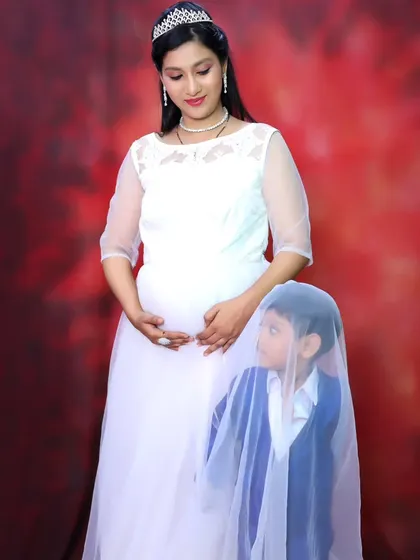 A sweet and imaginative maternity photo, with the older brother hiding under the veil of his mother's white gown.
