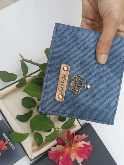 The personalized blue denim wallet held over its gift box with a rose, highlighting its gifting potential.