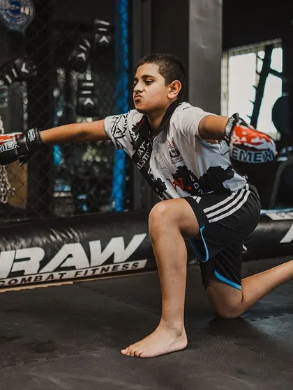 Before the fight comes respect. Here, a young warrior practices the Wai Kru, a traditional Muay Thai ritual honoring his teachers and the art itself. This is about building character, not just a fighter.