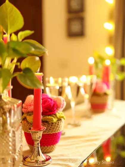 The soft focus on this shot captures the dreamy, warm atmosphere created by the candles and crochet flowers.