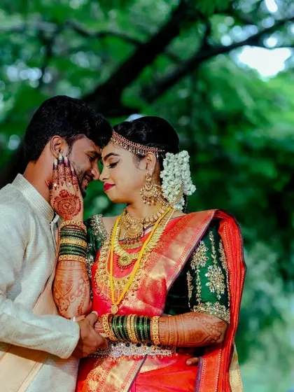 A beautiful, intimate portrait of a couple in traditional wedding attire. The bride's hand gently touching his face adds a layer of tenderness.