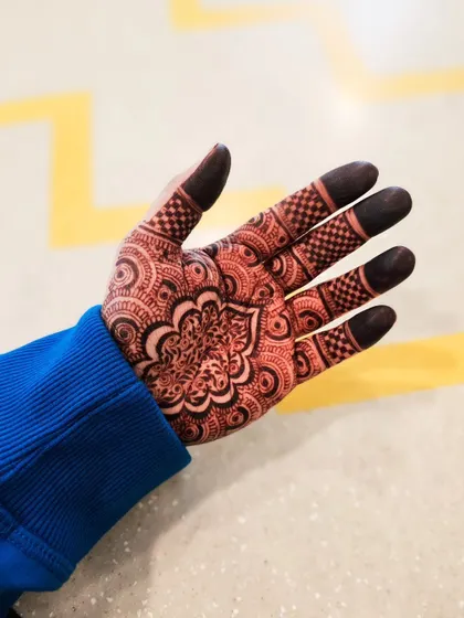 The stain progression on a detailed mandala design. The checkerboard pattern on the fingers and the intricate center look sharp and beautiful as the color darkens.