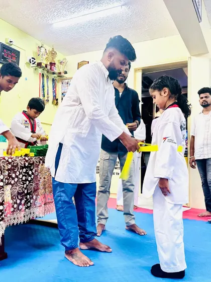 Awarding a new yellow belt to a dedicated young girl. Her journey in martial arts is just beginning.