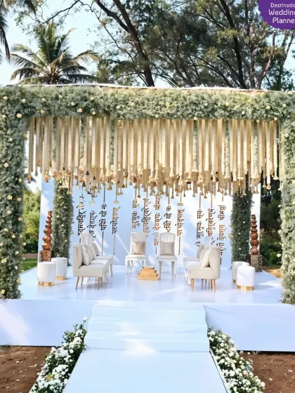 True luxury is in the details. This elegant mandap setup features a canopy of lush greenery and cascading white florals, creating a serene and sophisticated atmosphere for a daytime ceremony. It's about smart design, not just excess.