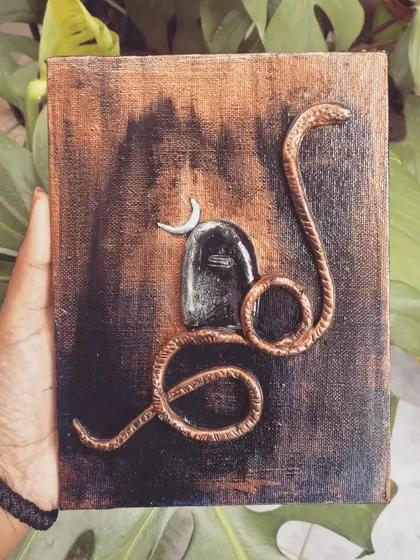 A mural-style painting of a Shivling with a serpent. The antique copper and black finish gives this piece a timeless and sacred feel.