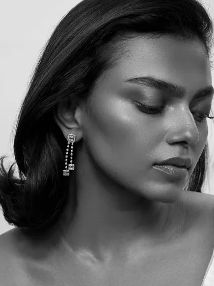 An elegant profile shot highlighting delicate drop earrings. The soft, diffused light creates a dreamy and sophisticated mood for this luxury jewelry campaign.