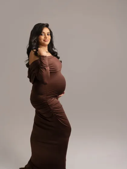 A simple, elegant profile in a rich brown gown. This classic pose is all about the silhouette and the quiet confidence of the mother-to-be.