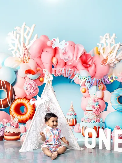A moment of calm in the sweet-themed wonderland. This little boy sits peacefully inside his lace teepee, a beautiful portrait from his first birthday session.