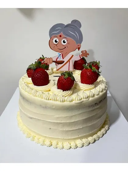 A special vanilla strawberry loaded cake with Italian buttercream frosting for a 75th birthday, complete with a cute granny topper.