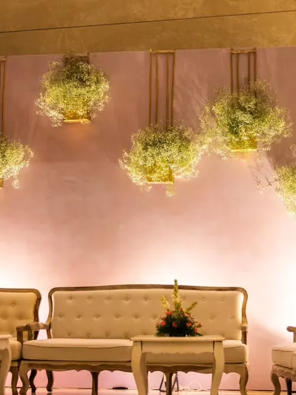 A chic and minimalist seating area I designed for a reception. The simple backdrop is elevated with hanging floral installations of baby's breath, creating a modern and elegant photo corner.