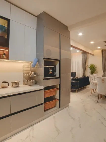 A view from the kitchen into the dining area in Ms. Megha Joshi's home. This shot highlights the tall unit with a built-in oven and microwave, showcasing our expertise in creating ergonomic and space-efficient kitchen layouts.