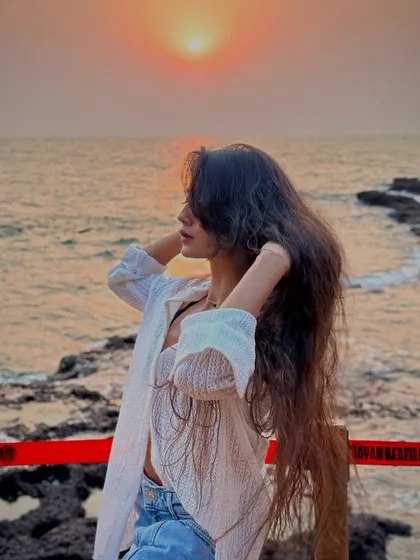 Letting my hair down by the sea at sunset. A perfect, breezy moment that embodies the freedom of being on vacation.