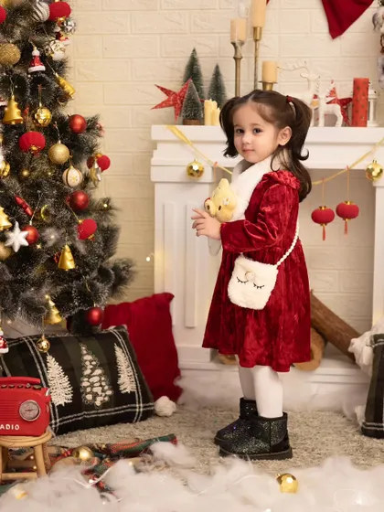 Posing by the Christmas tree. We create a magical winter wonderland in our studio to make your family's holiday photos extra special.