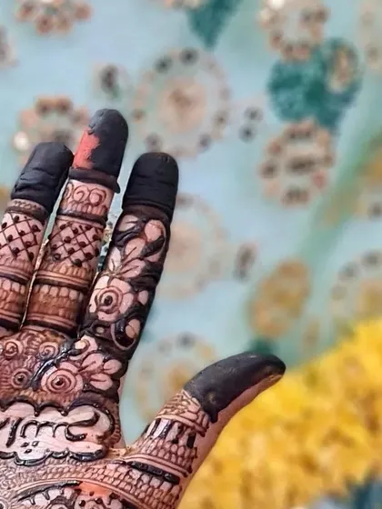 A detail shot of the personalized calligraphy on a bride's palm, surrounded by delicate floral and vine motifs.