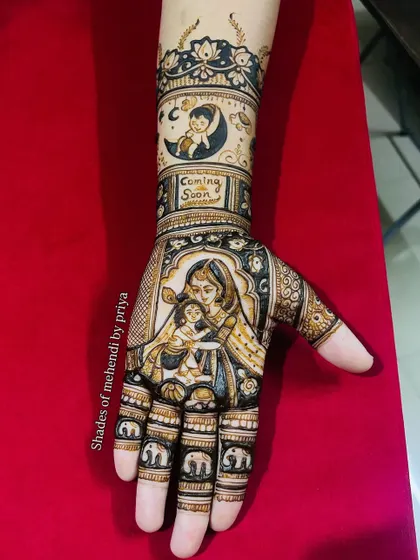 Celebrating the journey to motherhood with a custom baby shower mehendi. This design features a loving portrait of a mother and child, with a "Coming Soon" message and cute baby elephants on the fingers. It's a beautiful way to capture this precious time.