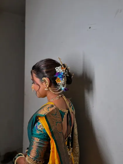 A side profile showing the beautiful details of her hairstyle, with flowers and accessories perfectly placed.