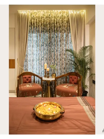 We created a cozy reading corner in this bedroom with a pair of elegant accent chairs and a small side table. The floral curtains and warm lighting make it an ideal spot to unwind.
