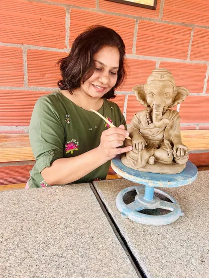 A photo of me with one of my finished Ganesha idols. This is my happy place.
