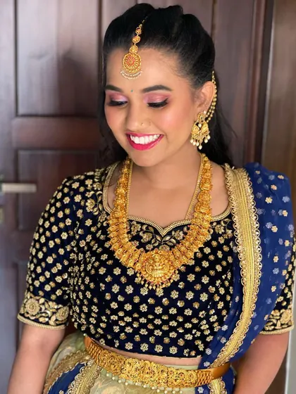 A radiant smile from my client Nisha. For her event, we chose a vibrant pink lip and shimmery pink eyeshadow to complement her deep blue and gold outfit, along with traditional temple jewelry.