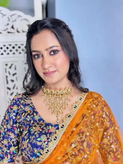 The complete look, with the smokey eyes perfectly balancing the colorful lehenga. A stunning choice for a Sangeet or reception.
