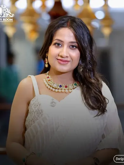 This client looks stunning in her white saree. The makeup is classic and elegant, letting her beautiful smile and colorful necklace stand out.
