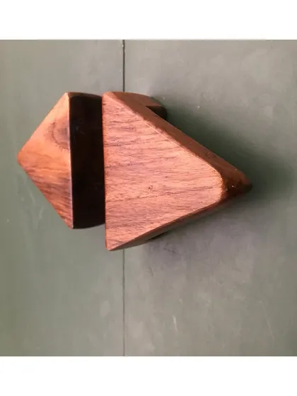 Even small details matter. This custom-designed wooden handle, created for a minimalist residential project, features a geometric, arrow-like shape. It is a small piece of functional sculpture that adds a unique touch to the cabinetry.